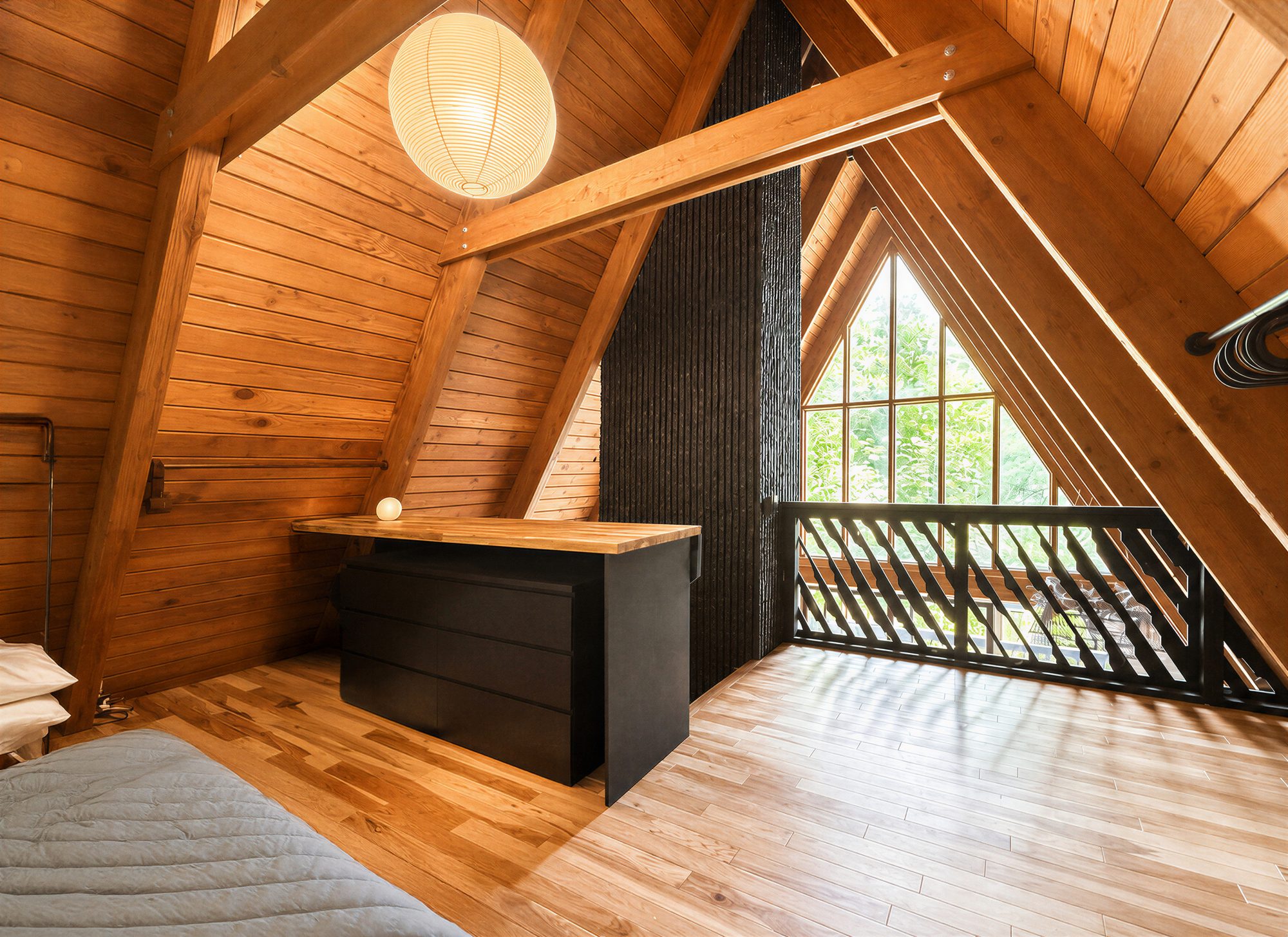 Mezzanine bedroom under the A-frame peak with paper lantern