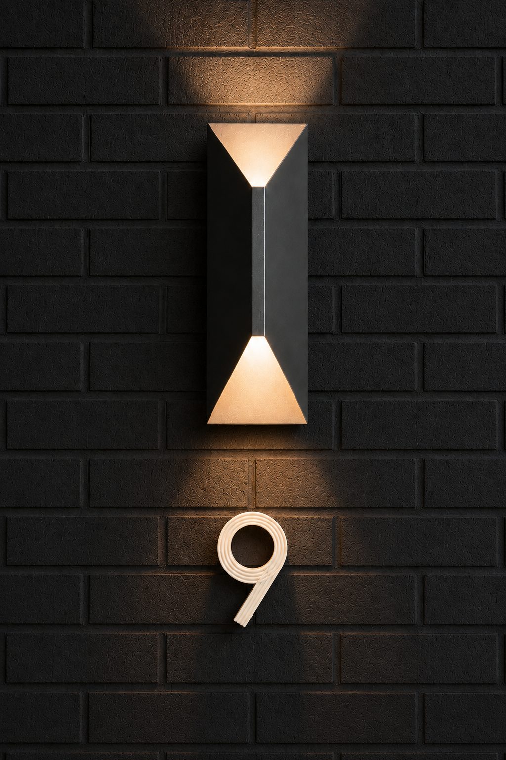 Black brick wall with a sculptural sconce and house number nine