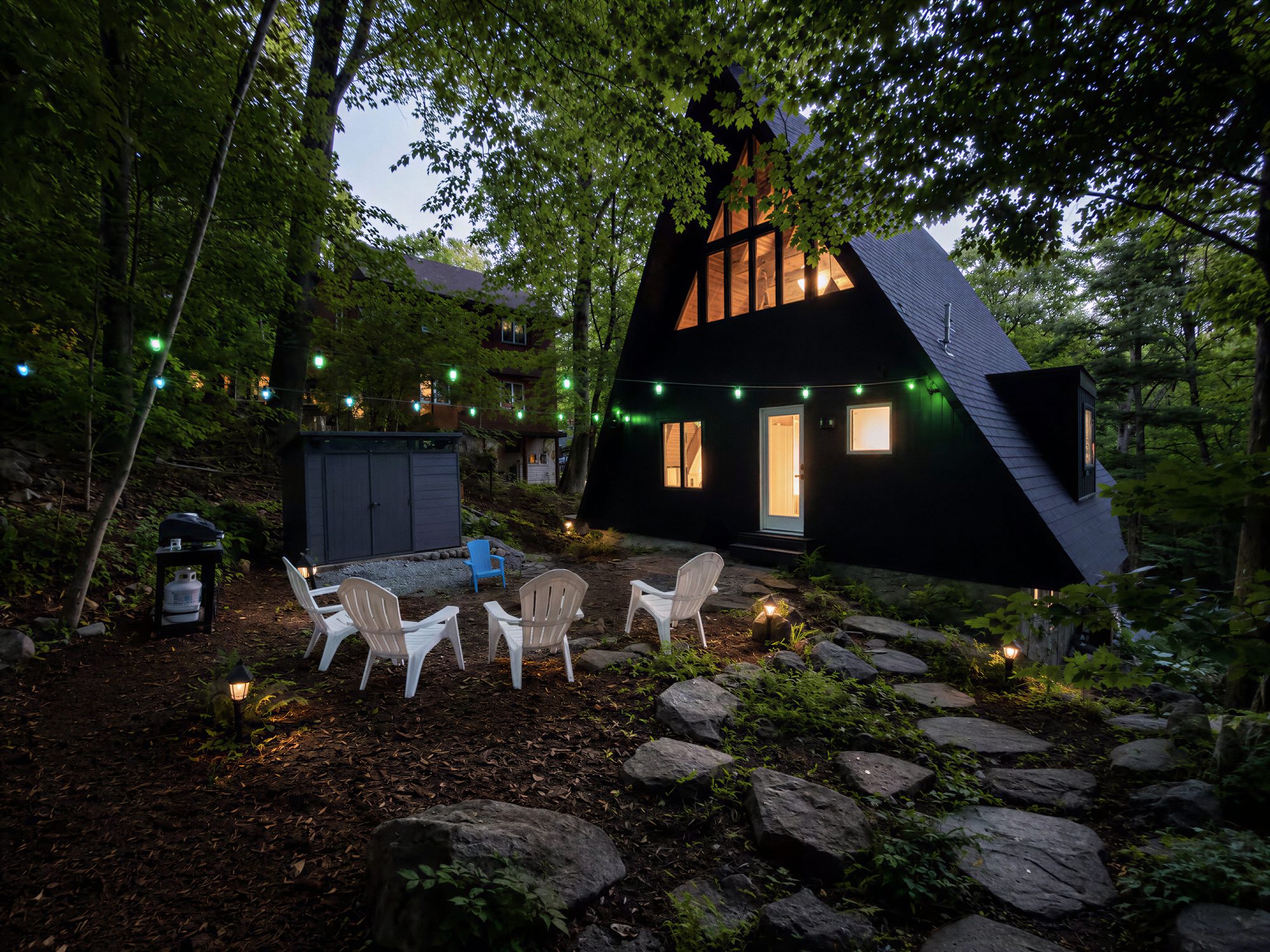 The A-frame patio at dusk with string lights and chairs